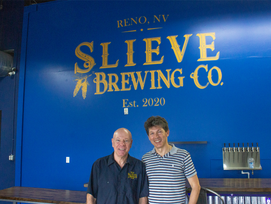 Philip Mountain and Dr. Igor Makienko stand in front of the Slieve Brewing Company logo.