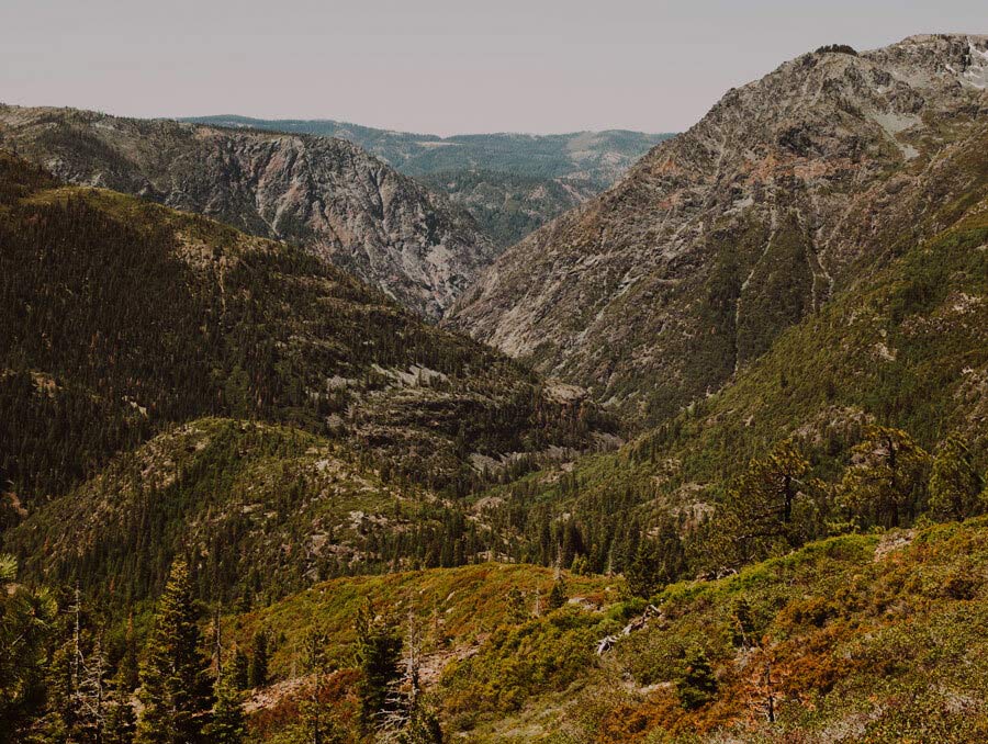 A mountainous landscape shows a canyon carved by a river.