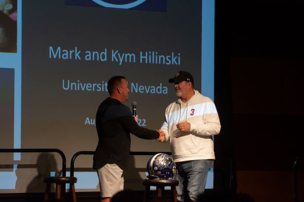 Two men shaking hands on stage.