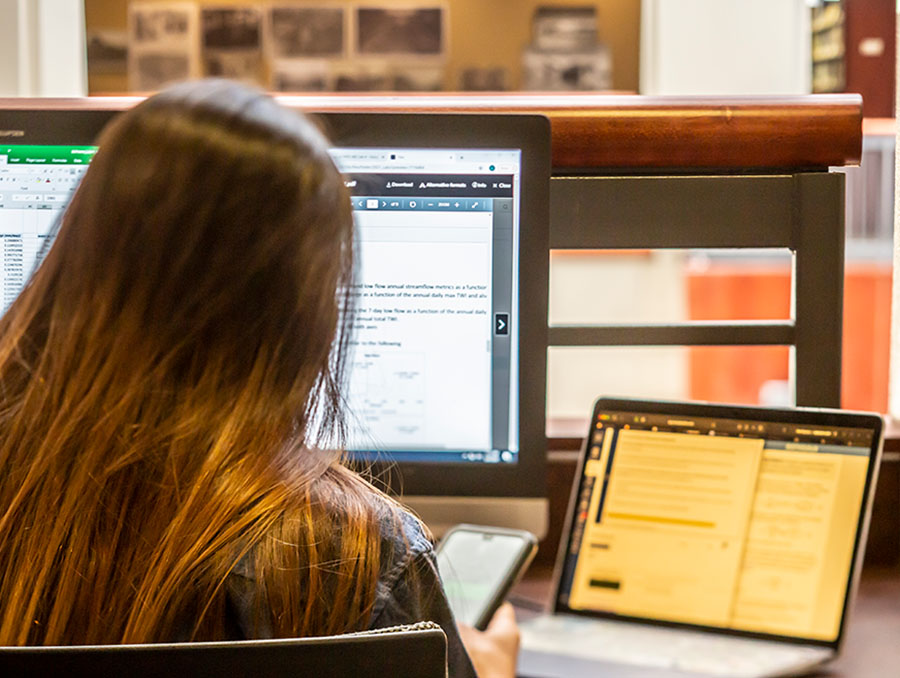 A University student sits in front of a computer inside the Mathewson-IGT Knowledge Center. 