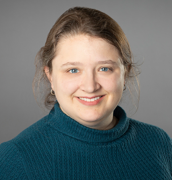 Portrait of Elspeth Olsen with her hair pulled back, wearing a dark green turtle neck sweater.