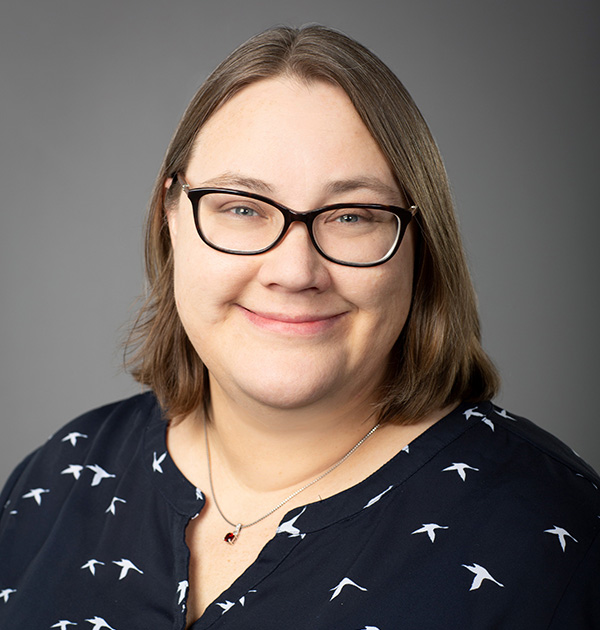 Portrait of Kim Anderson wearing a navy blouse with a white bird print.