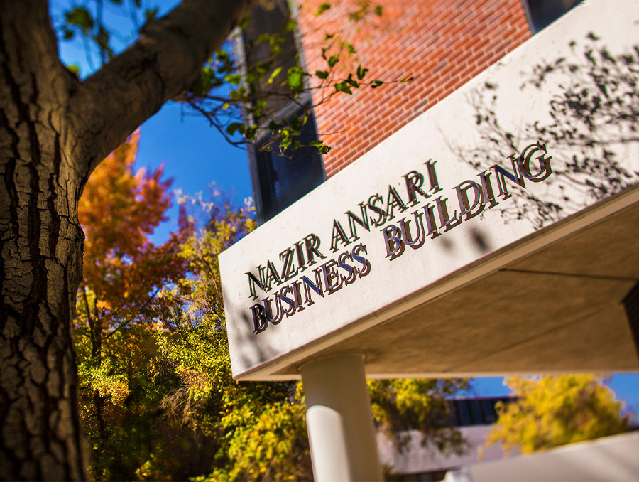 Concrete sign on the Ansari business building above the entrance that reads Nazir Ansari Business Building