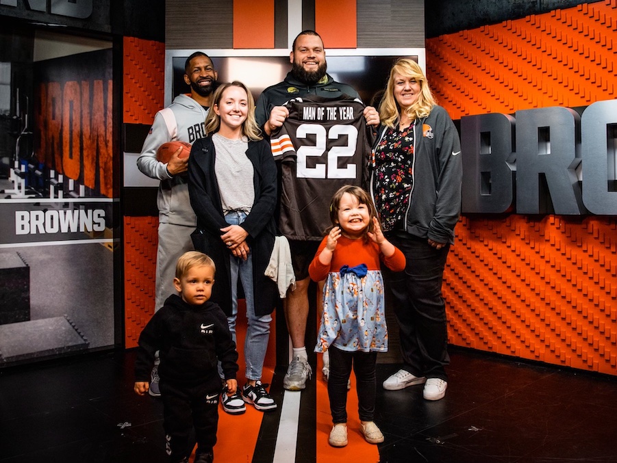 Joel Bitonio poses next to his children and wife, Courtney, and his mother while in the Cleveland Browns room accepting the Man of the Year award.