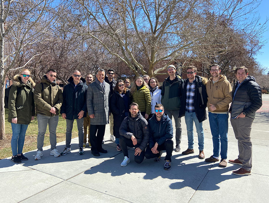 Students stand outside in the sun with University President Brian Sandoval