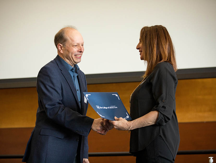 Dean Casilde Isabelli handing an award to an esteemed faculty member.