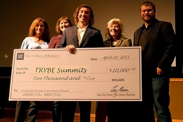 Five people holding a giant check awarding $10,000 to TRYBE Summits with the memo Dragonfly Energy Innovation Award