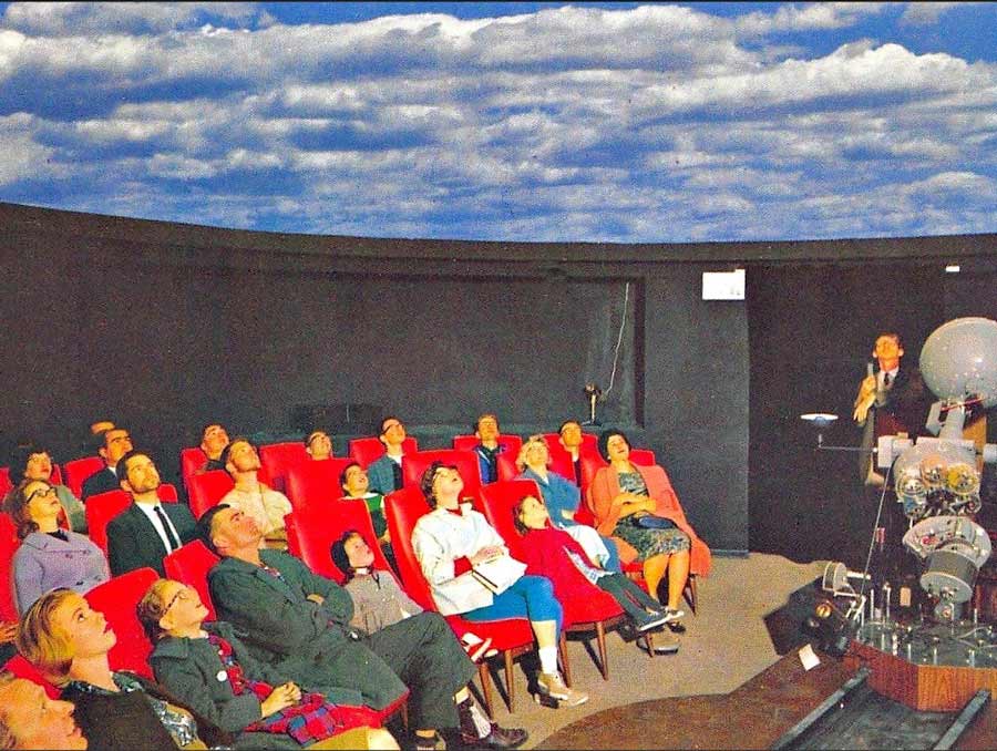 Audience in the Full-Dome Theater in 1963 watching the blue sky and clouds projected on the ceiling at the Fleischmann Planetarium.