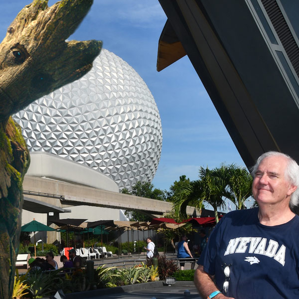 Jim Carson smiles in an edited photo with "Groot" from the movies and comics "Guardians of the Galaxy". Carson is wearing a blue Nevada shirt.