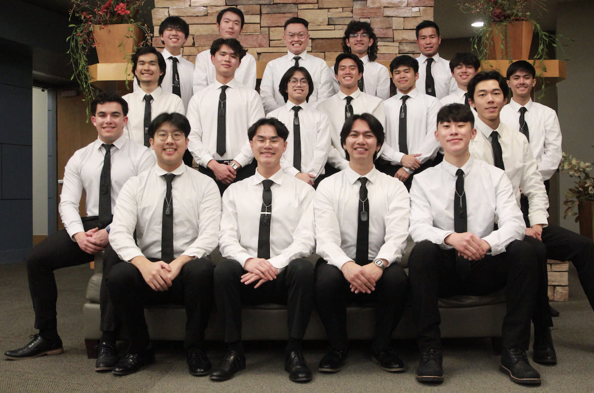 Group of boys in white button ups, black slacks, black neck ties and black dress shoes. 