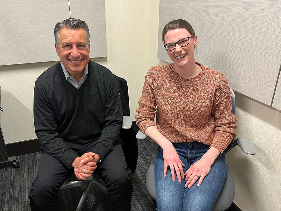 President Sandoval sits to the left of Jess Buelow in a podcast recording room.