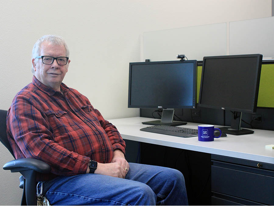 Man sitting at a desk, looking at the camera.