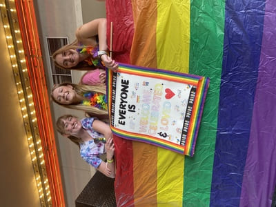Three people standing on the float decorated in pride decorations