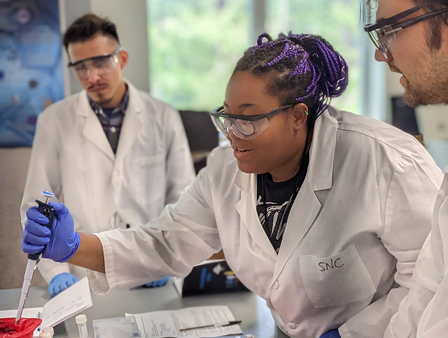 Microbiome camp with three students engaged in research.