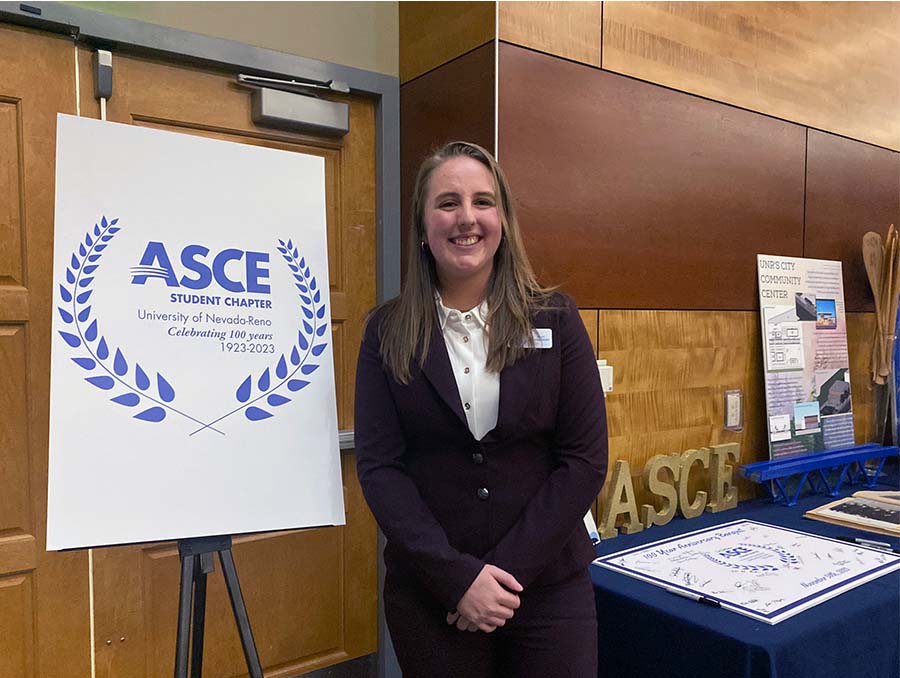 Karlie Del Santo stands next to a sign that reads ASCE 100