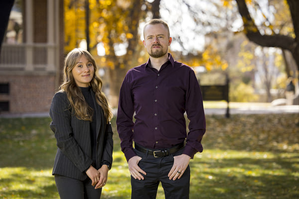 Alexis McGuire and Christopher Blair standing on the quad, smiling.