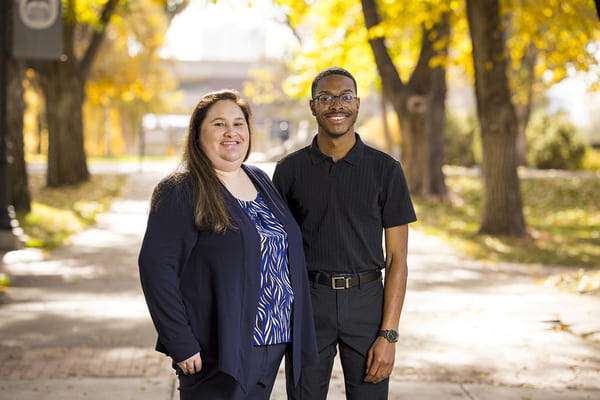 Angelina Padilla and Tyreis Gatson stand outside smiling on the quad.