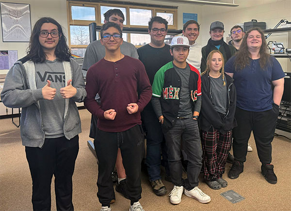 Six teenagers standing in a classroom