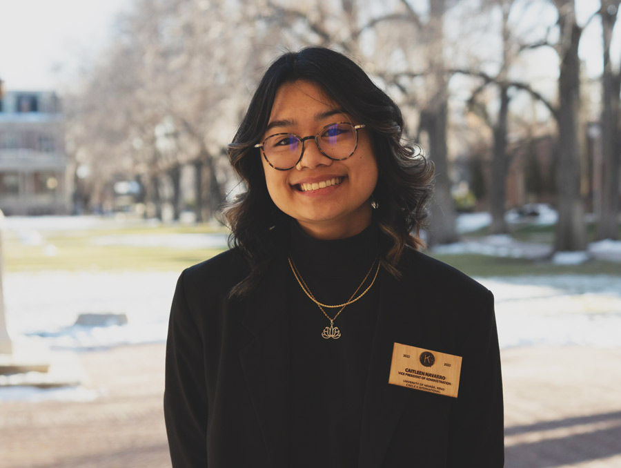 Caitleen Navarro smiles in front of the Quad wearing a Circle K nametag.