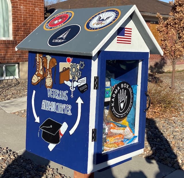 Blue box with painted decorations from the Veteran Alumni Chapter (brown boots, grey mechanical gears and black graduation cap with a white diploma).