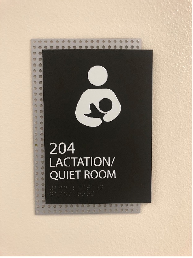 A sign that has an icon of a person holding an infant with the words "204 Lactation/Quiet Room" written on it.