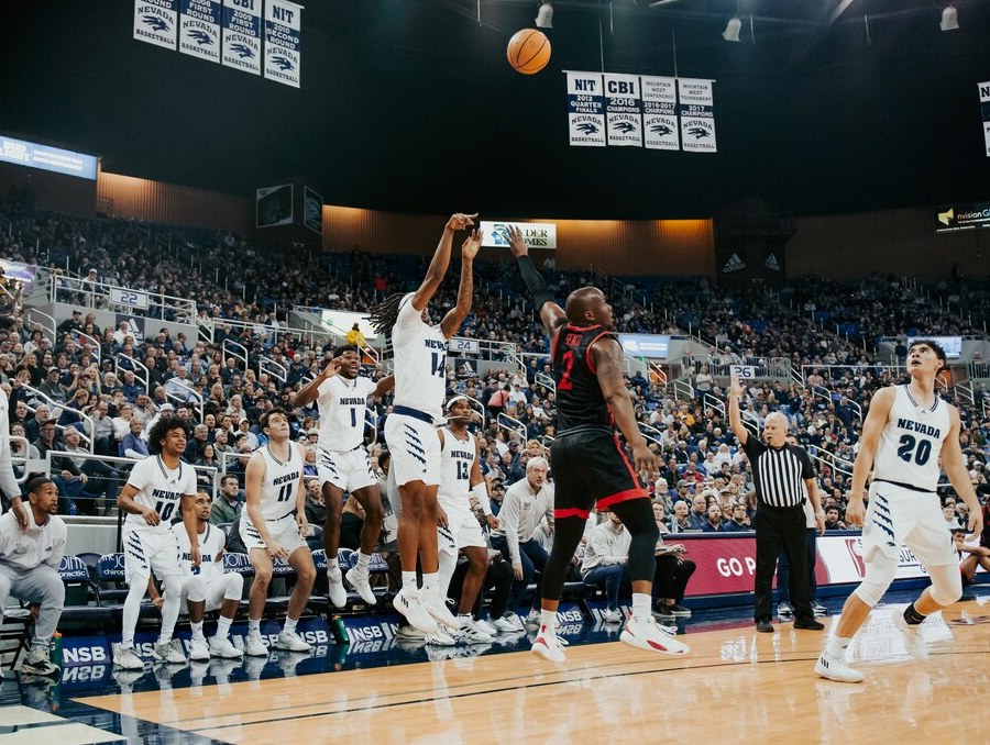 Tre Coleman shoots a 3 pointer and the home team bench cheers. 