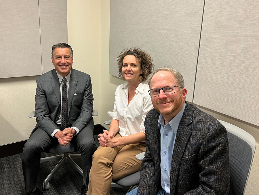 President Sandoval sits to the left of Kari Barber and Al Stavitsky in a podcast recording room.