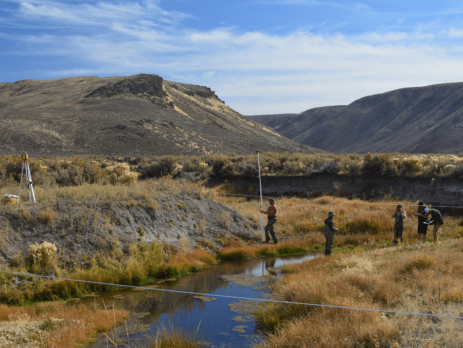 Students in the program survey a creek.