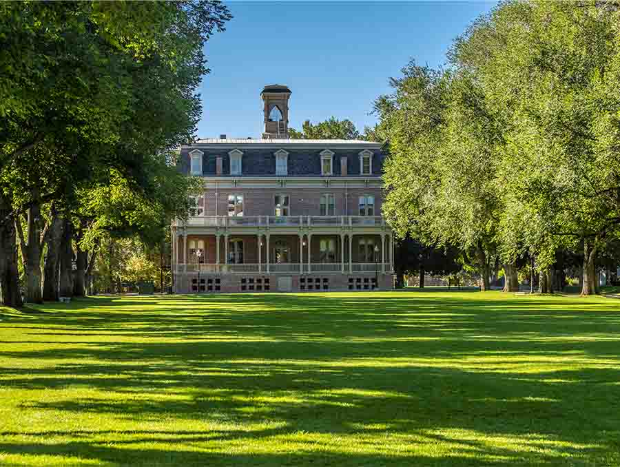 Exterior of Morrill Hall with green lawn front, trees to the left and right. 