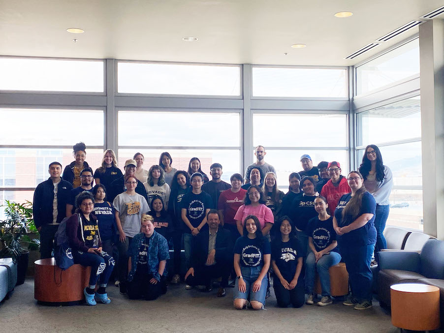 A large group of about 33 smiling people posing for the camera inside the JCSU with Dean Kemmelmeier in the front.