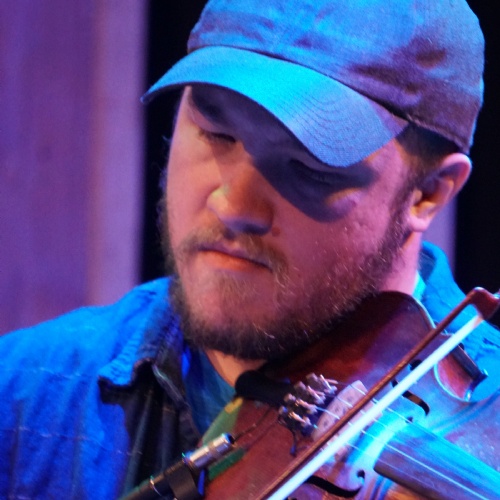 Graham Marshall headshot while he plays the violin.