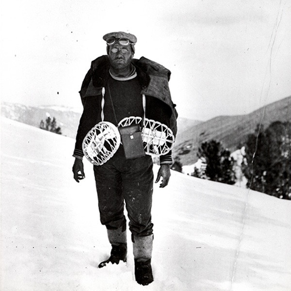 James Church in rudimentary snow gear standing outside on a snowy mountain top.