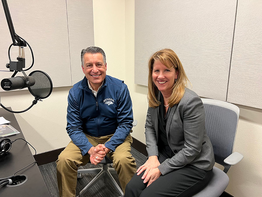 President Sandoval sits to the left of Stephanie Rempe in a podcast recording room.