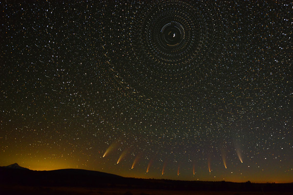 A lace-like pattern shows a stacked image of the night sky featuring a comet nearing the horizon on the bottom of the image.