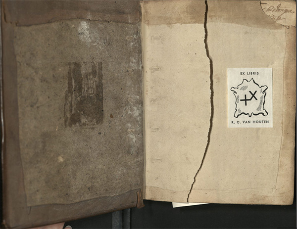 Opened volume, with rough leather binding and exposed board, torn flyleaf, and loose modern bookplate of black and white hide and the name “R. C. Van Houten.”