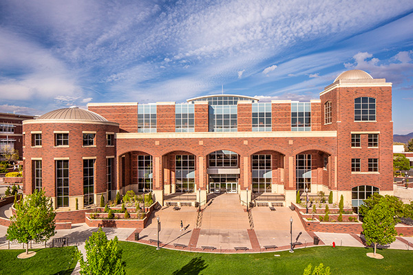 The Mathewson-IGT Knowledge Center exterior; red brick and large arches mark the front of the building along with a large patio and sweeping, wide stairs.