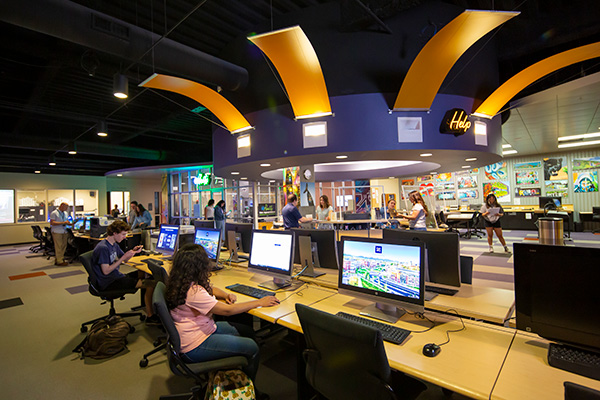 Wide shot of the main @One floor. There are rows upon rows of computers, the lendable technology department can be seen along with the printing area.