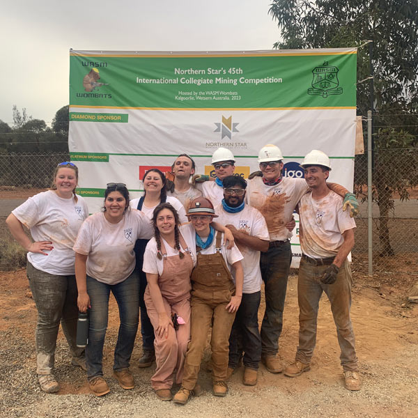 The Mackay Muckers team poses for a photo. They are all covered in dirt.