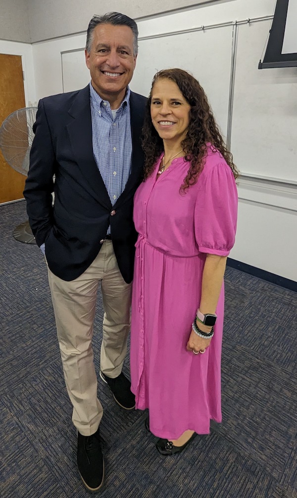 President Brian Sandoval smiles with Assistant Professor Nora Constantino