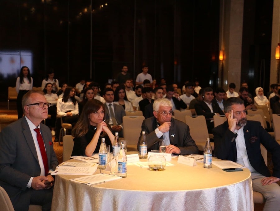 Ozmen Center mentors and start-up school competition judges sit at a table in a conference space