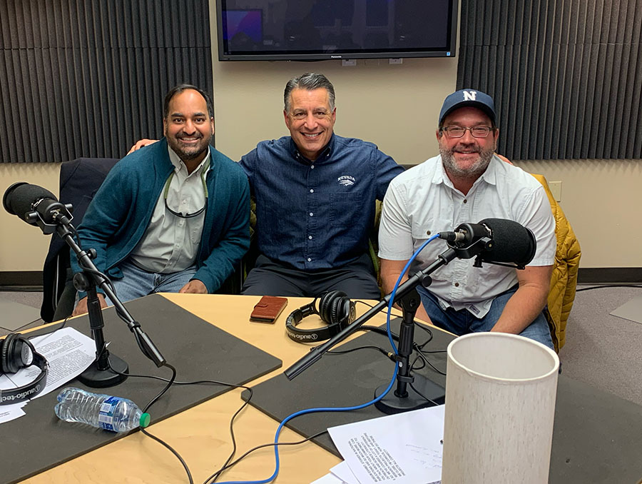 Sudeep Chandra sits to the left of President Sandoval with Zeb Hogan on the right in a podcast recording room with three mics on the table in front of them.