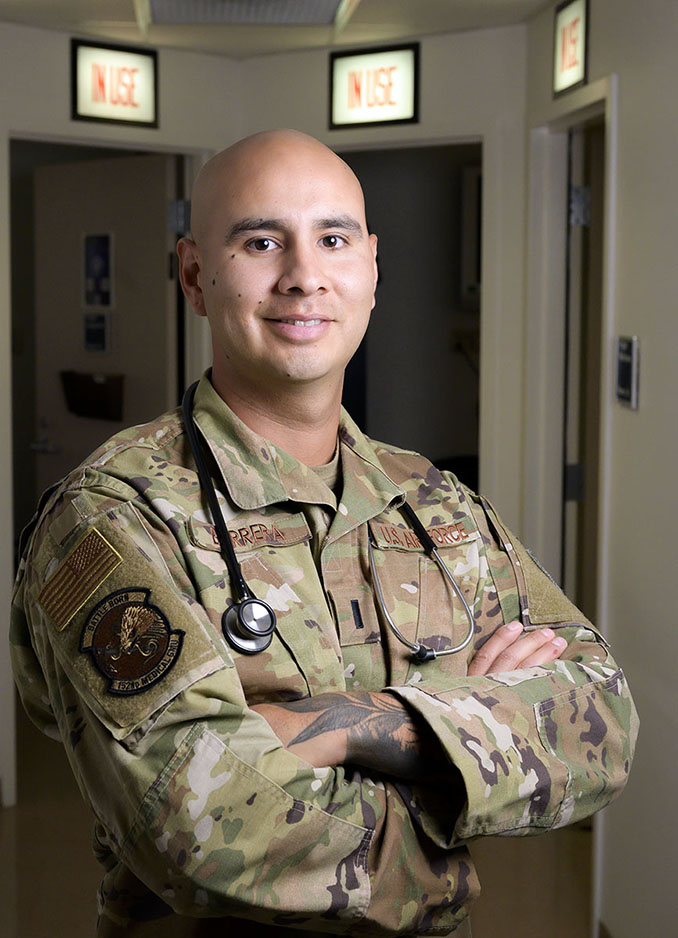 Nephtali Barrera poses in the hallway with his arms crossed and a stethoscope around his neck.