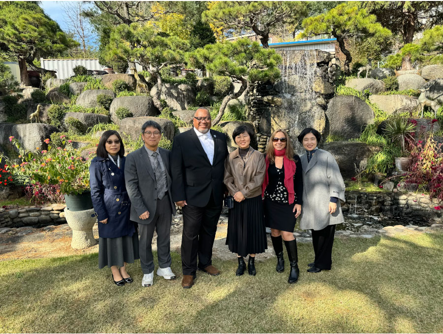 University officials from Korea and the University of Nevada, Reno in front of a garden in South Korea