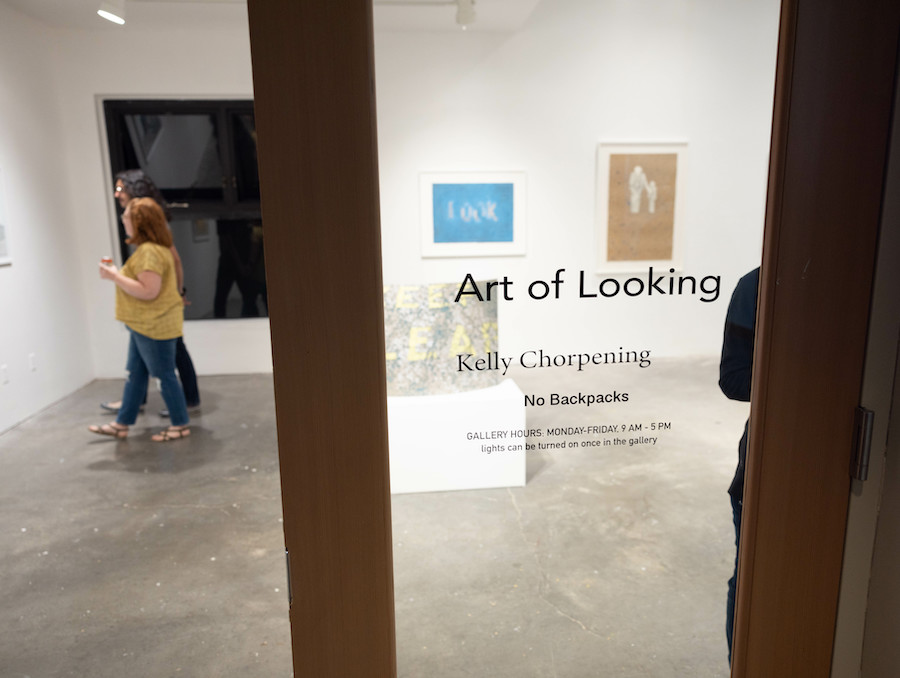 Two people enjoy the Art of Looking art exhibit by Kelly Chorpening