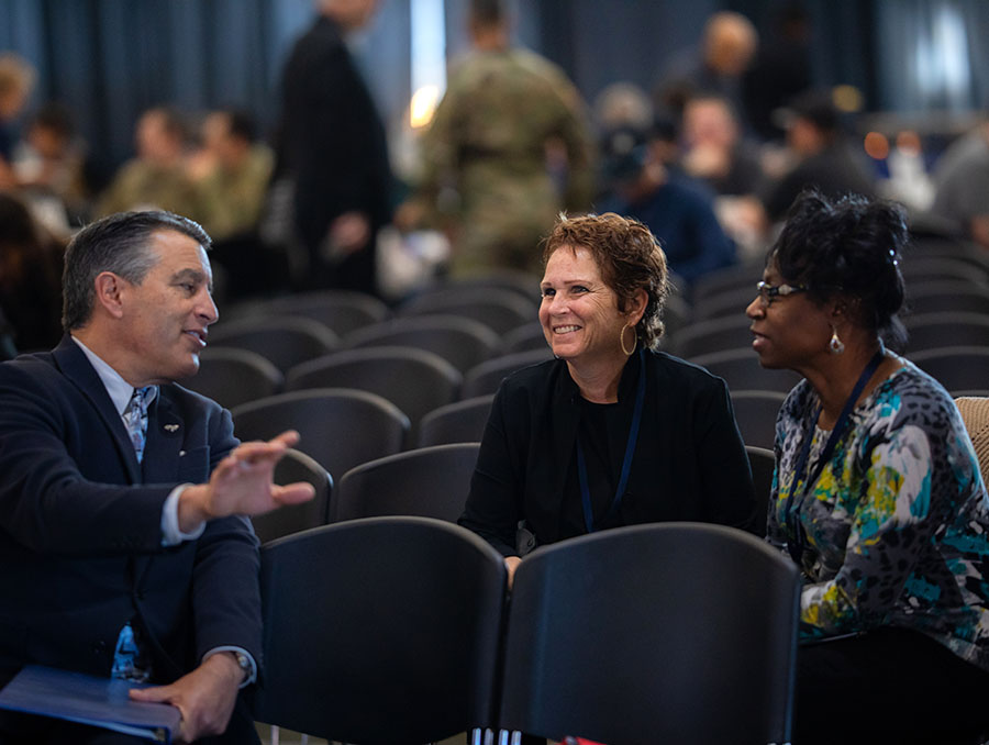 University President Brian Sandoval, Cybersecurity Center Director Nancy LaTourette and NSA cybersecurity expert Tamela Dukes sitting in chairs and talking.