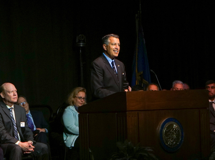 President Sandoval smiling on stage during the State of the University address.