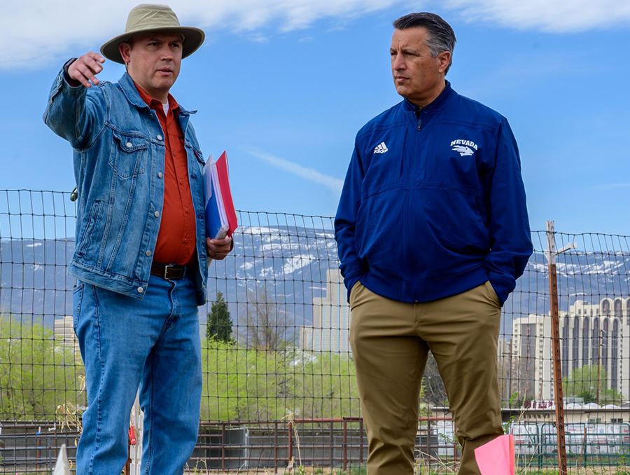 Alejandro Andrade-Rodriguez talking with University President Brian Sandoval outside at the alfalfa test fields. 