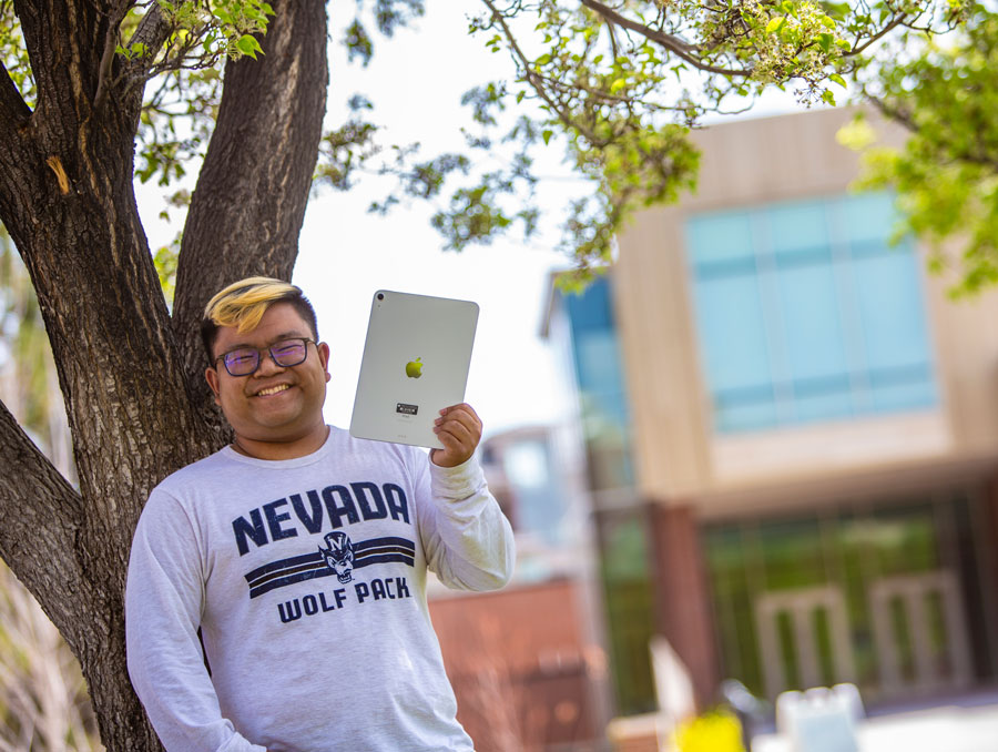 A student holds an iPad outside