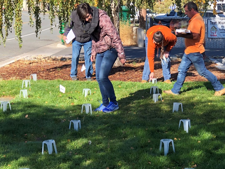 Four professionals conduct a water audit in the ground outside.