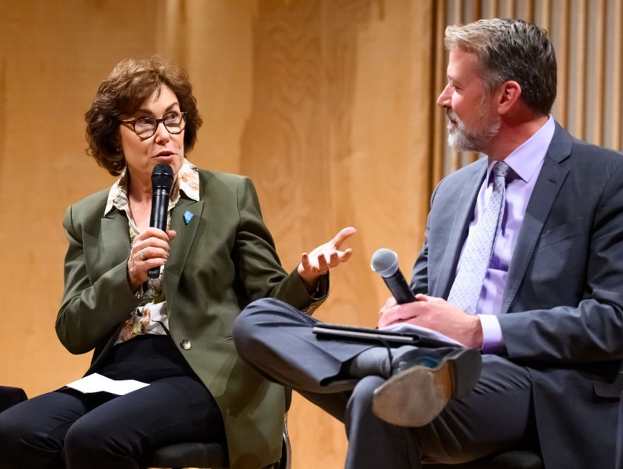 Sen. Jacky Rosen holding microphone and looking at Dr. Brian Erling during roundtable discussion on healthcare.